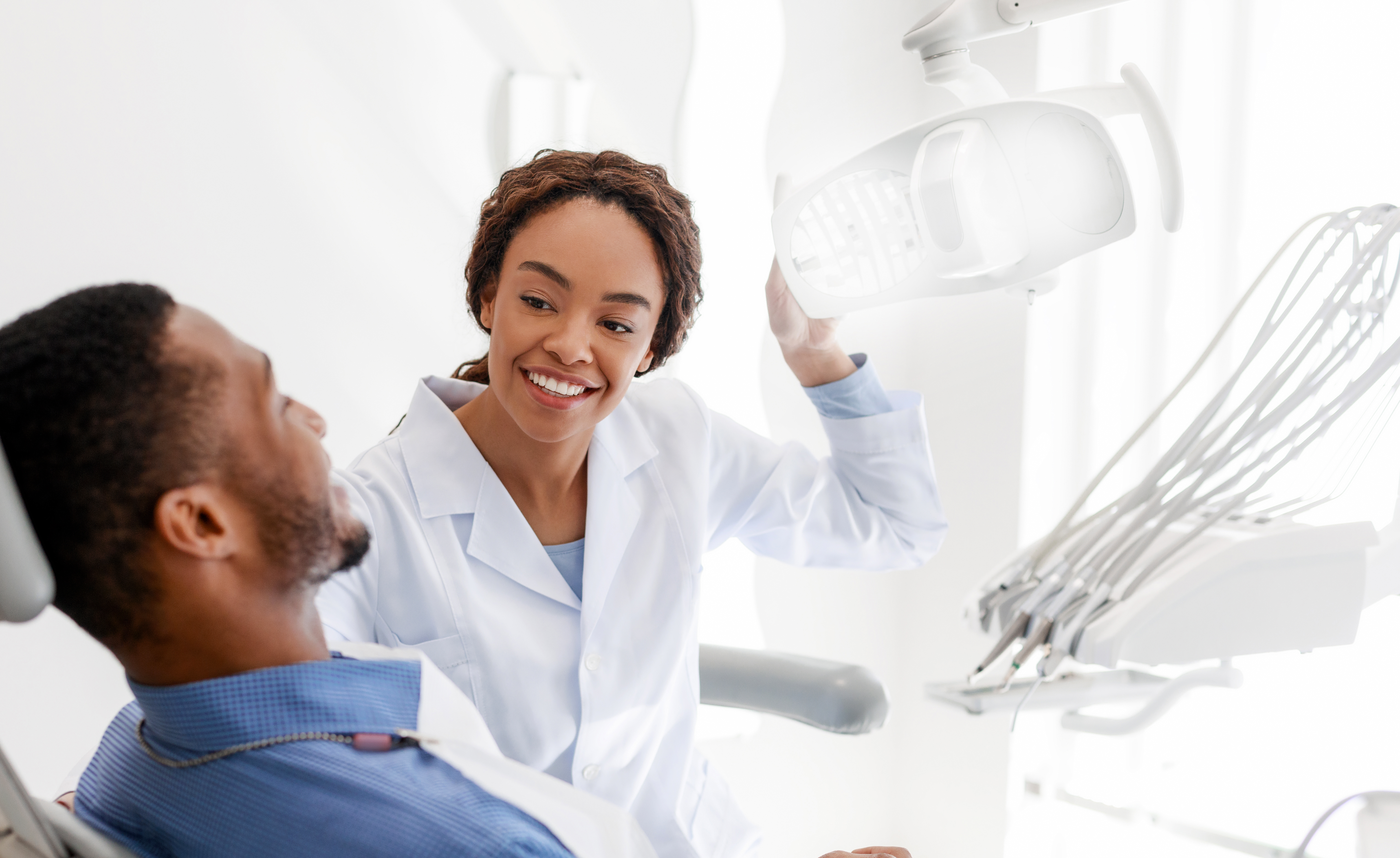 female dentist turning on lamp before treatment
