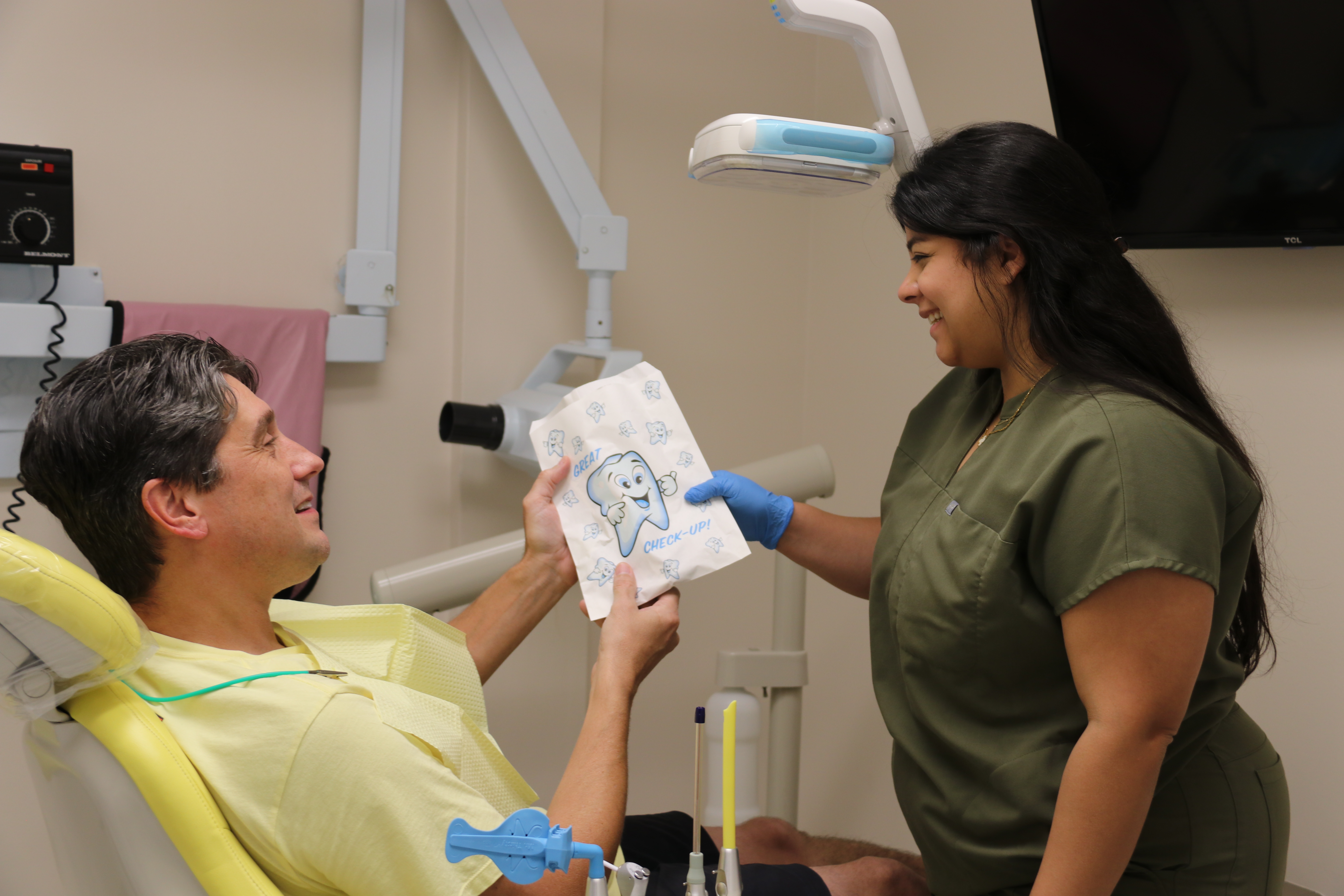 Asistente dental con paciente sonriendo